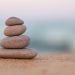 Stacked stones on a sandy beach symbolizing harmony and inner balance