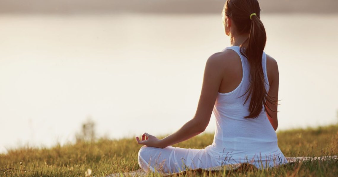 woman practicing yoga outdoors at sunrise — supporting hormonal balance in autumn